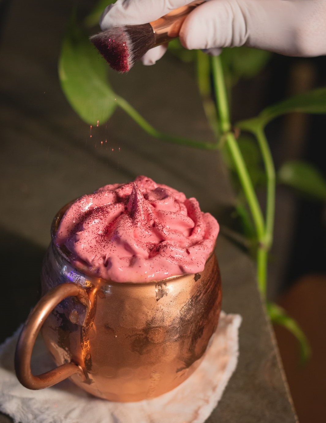 Brilhosinho Mule, feito com suco de maracujá com gengibre coberto por uma espuma de geleia de frutas vermelhas e glitter