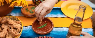 Mesa posta com tecido em amarelo e azul, com pratos da comida mexicana, como chilli e nachos, uma opção para aproveitar rodízios diferentes em Goiânia